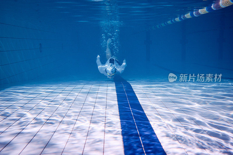 Male swimmer swimming underwater in a pool